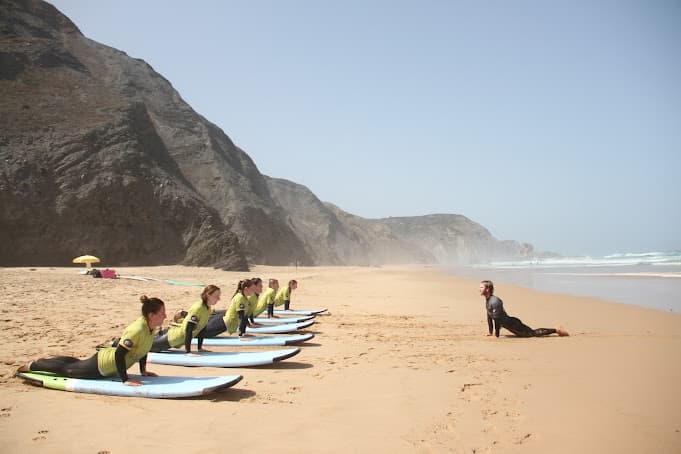 A group of students and the surf instructor on the beach