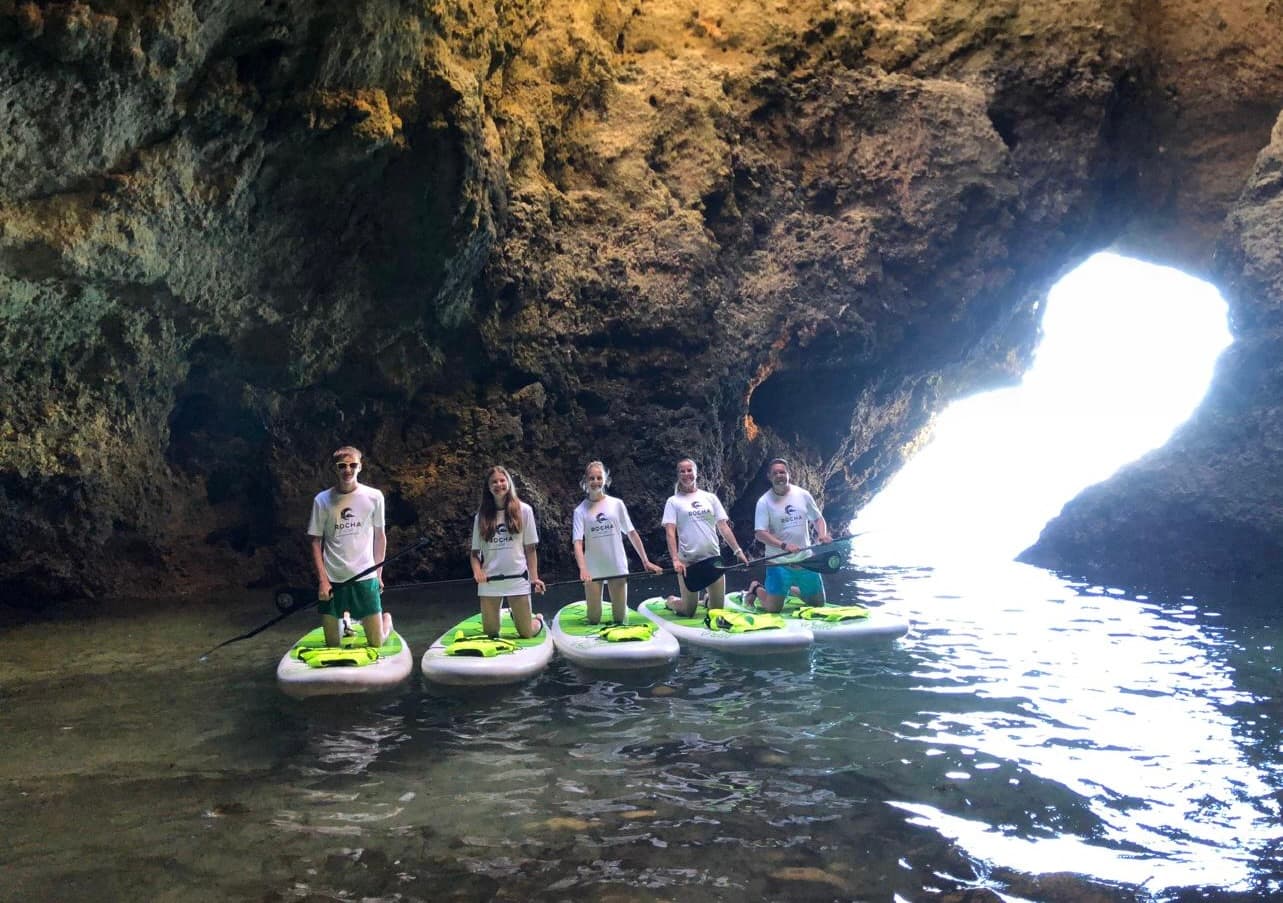 A group on a SUP Tour exploring hidden caves.