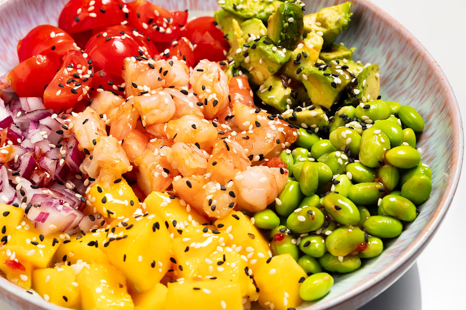 A close-up of a fresh and colorful poké bowl filled with tuna, avocado, and other healthy ingredients.