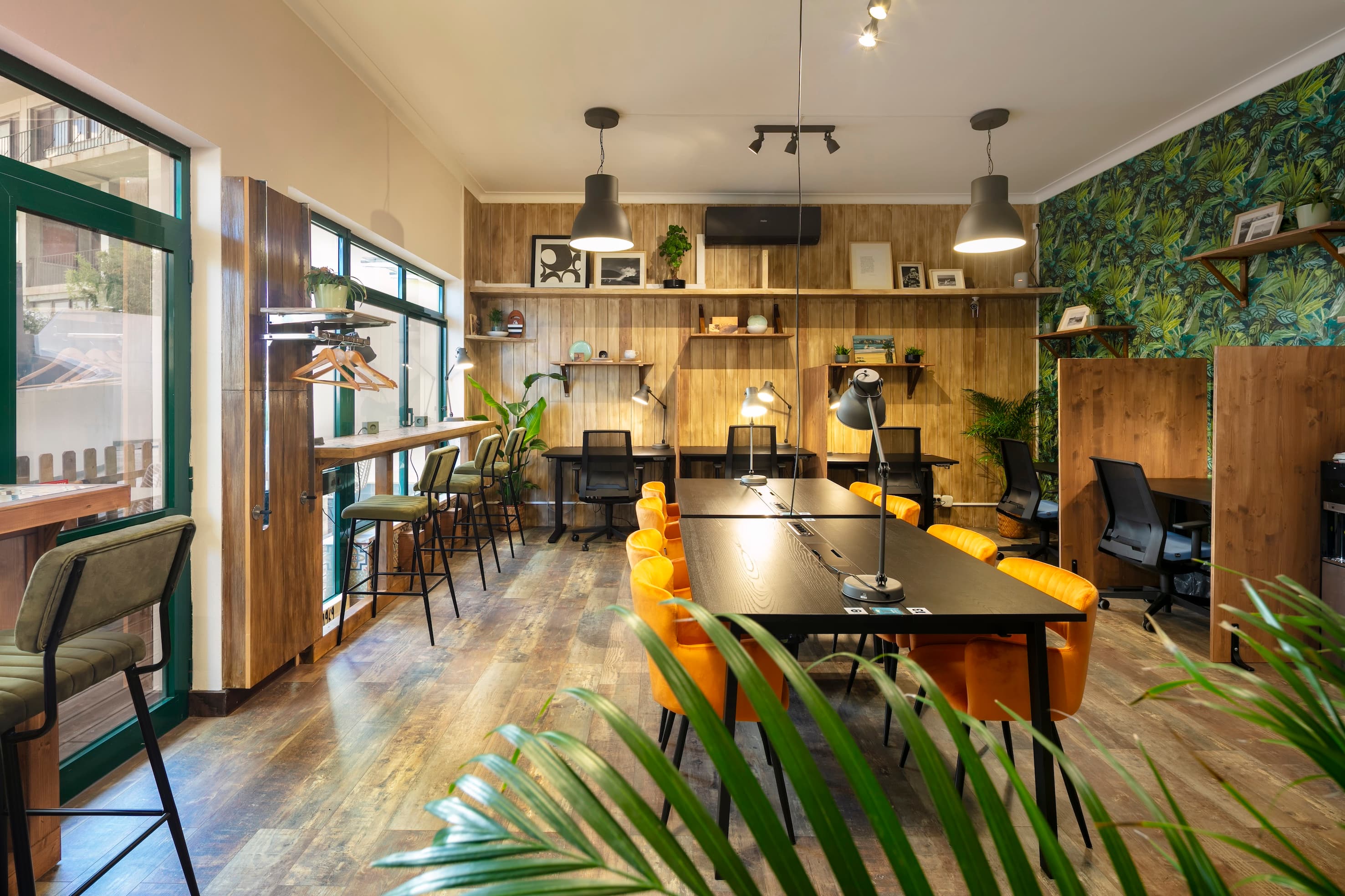 Bright coworking space with shared desks, private workstations, and modern decor.